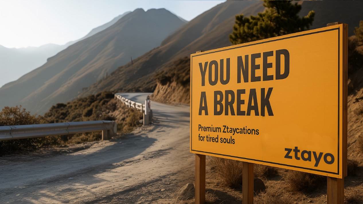 Ztayo campaign billboard reading You Need A Break, sited on a mountain road at sunrise